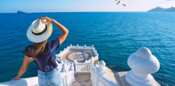 Girl holding a hat on head on a balcony in Benidorm