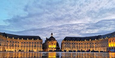 Bordeaux building with cloudy sky.