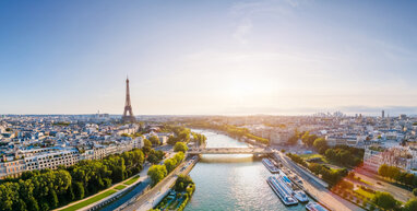 River through Paris with the Eiffel Tower in the distance.