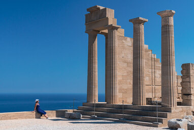Girl leaning on wall at Lindos Acropolis