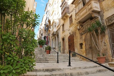 Stairs in Valletta with tall buildings each side.