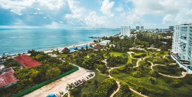 Cancun hotels with green fields and sea.