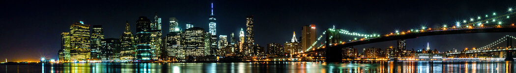 Manhattan skyline at night with bridge.