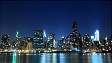 Picture of New York buildings taken at night from the water. 