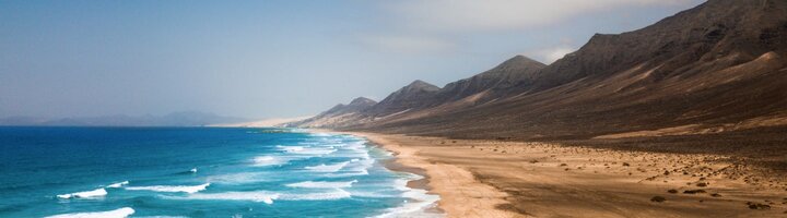 Beach, waves and large sand dunes.