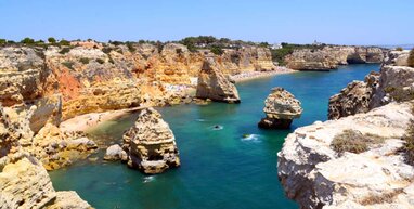 Beach at Faro. Blue sea with rock formations