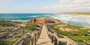 Path with rails leading down to the sea in Faro