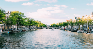 River going through Amsterdam with trees along the edge