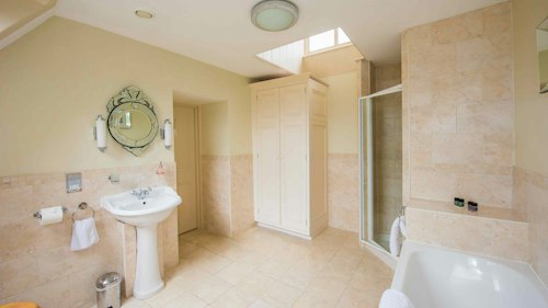 Shendish Manor Hotel - spacious bathroom with sink, shower and bath options. Mirror above sink and amenities provided.