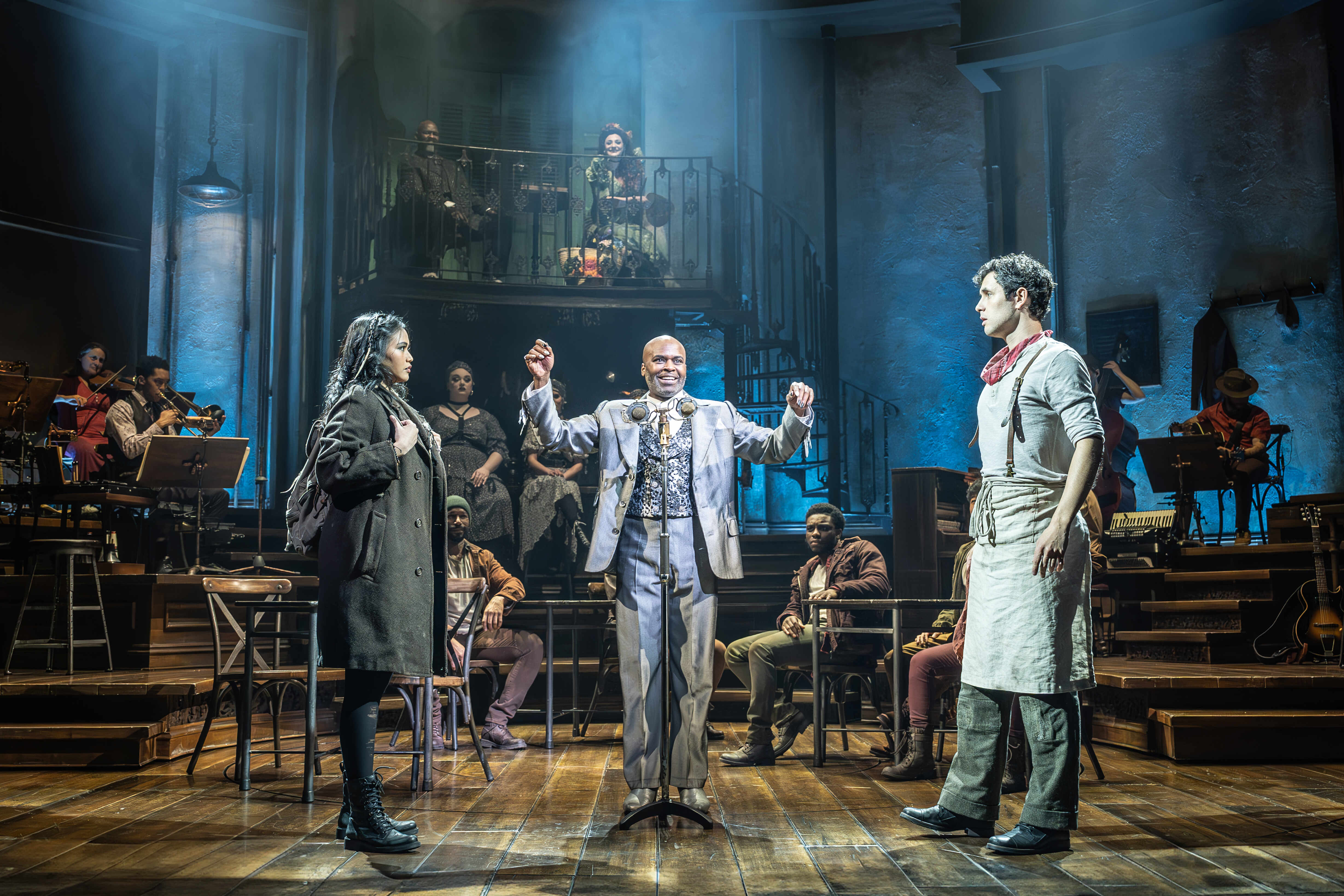 Hadestown performer framed in dramatic spotlight – photo by Marc Brenner