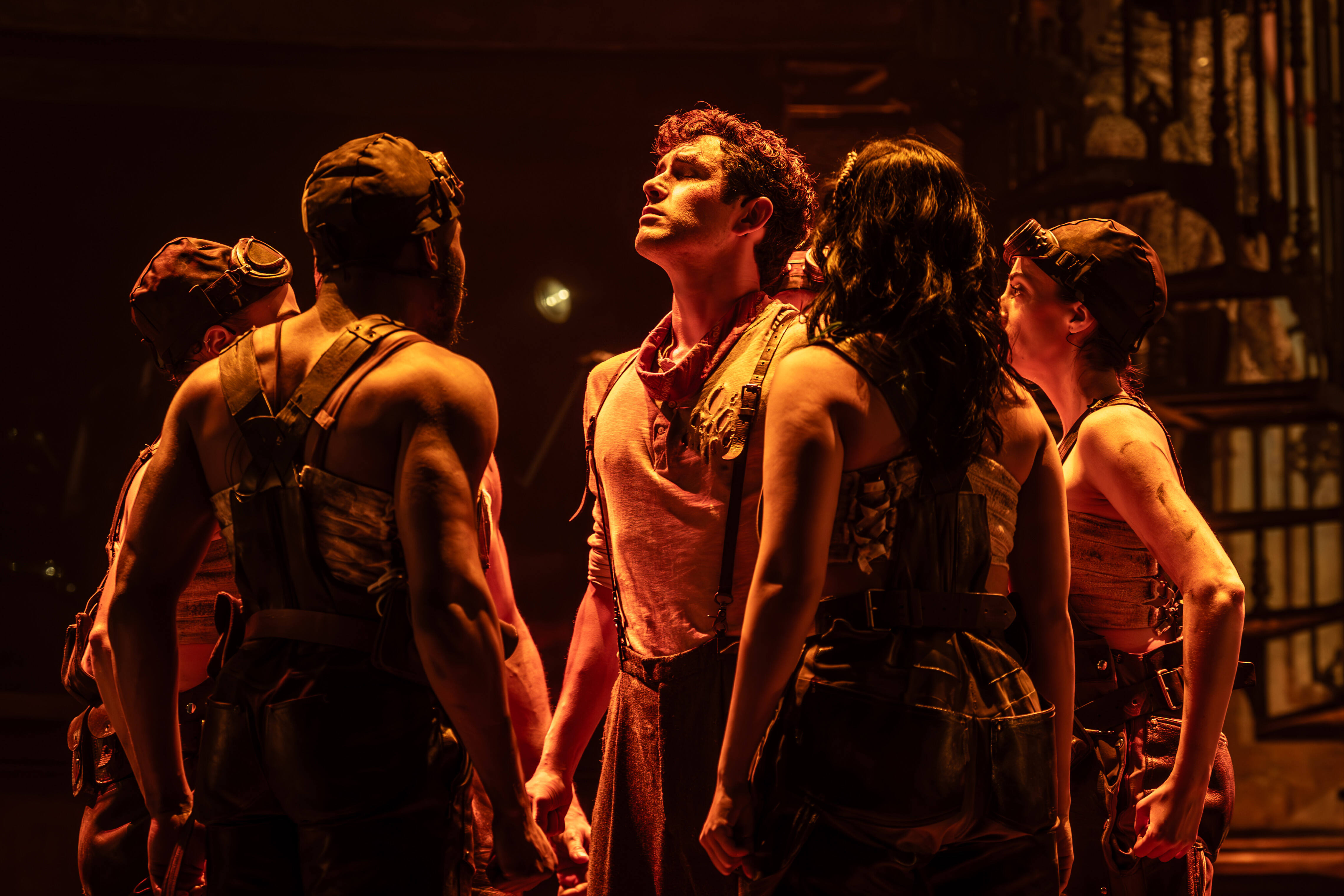 Hadestown cast on stage with atmospheric backdrop – photo by Marc Brenner