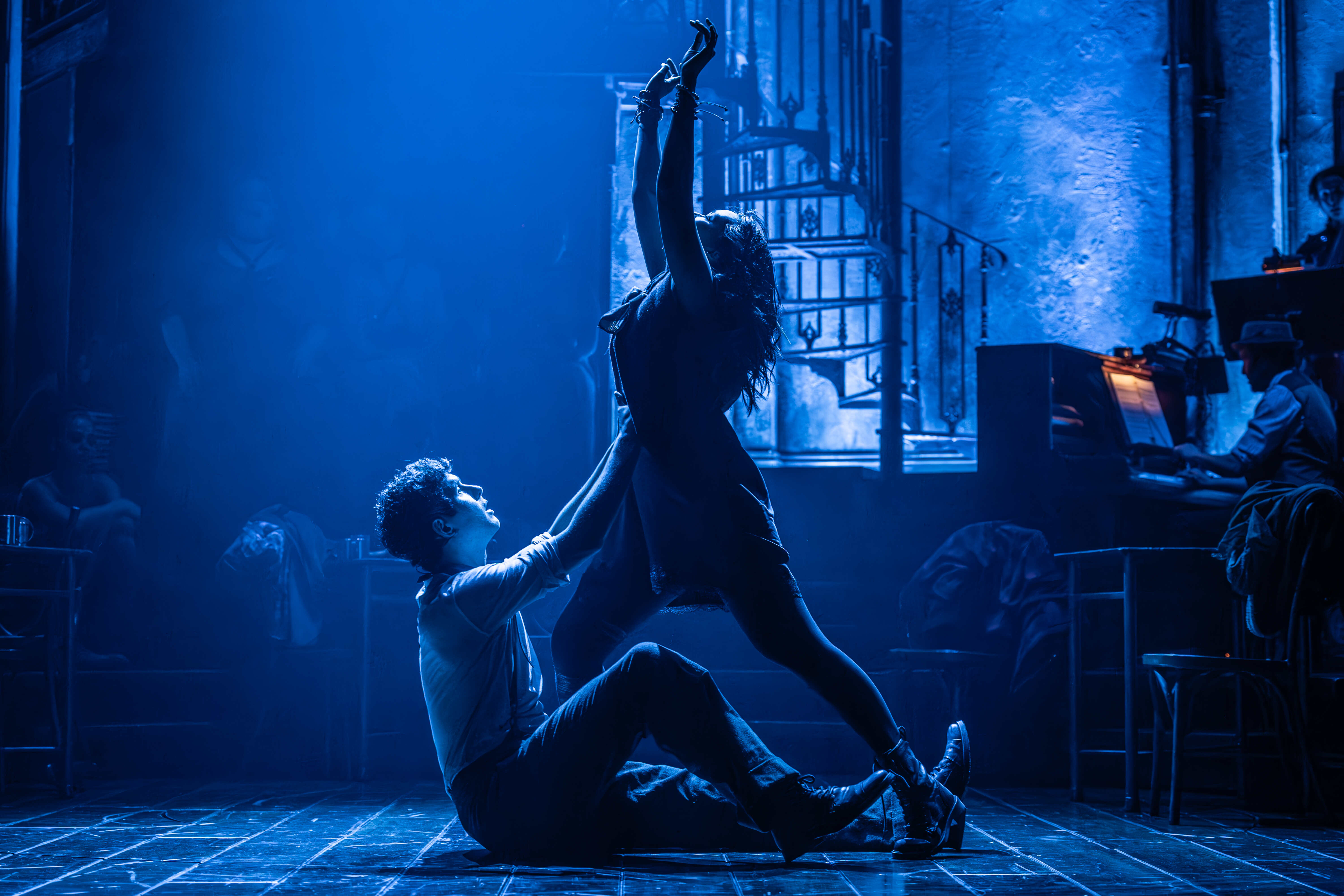 Performers singing with passion in Hadestown – photo by Marc Brenner