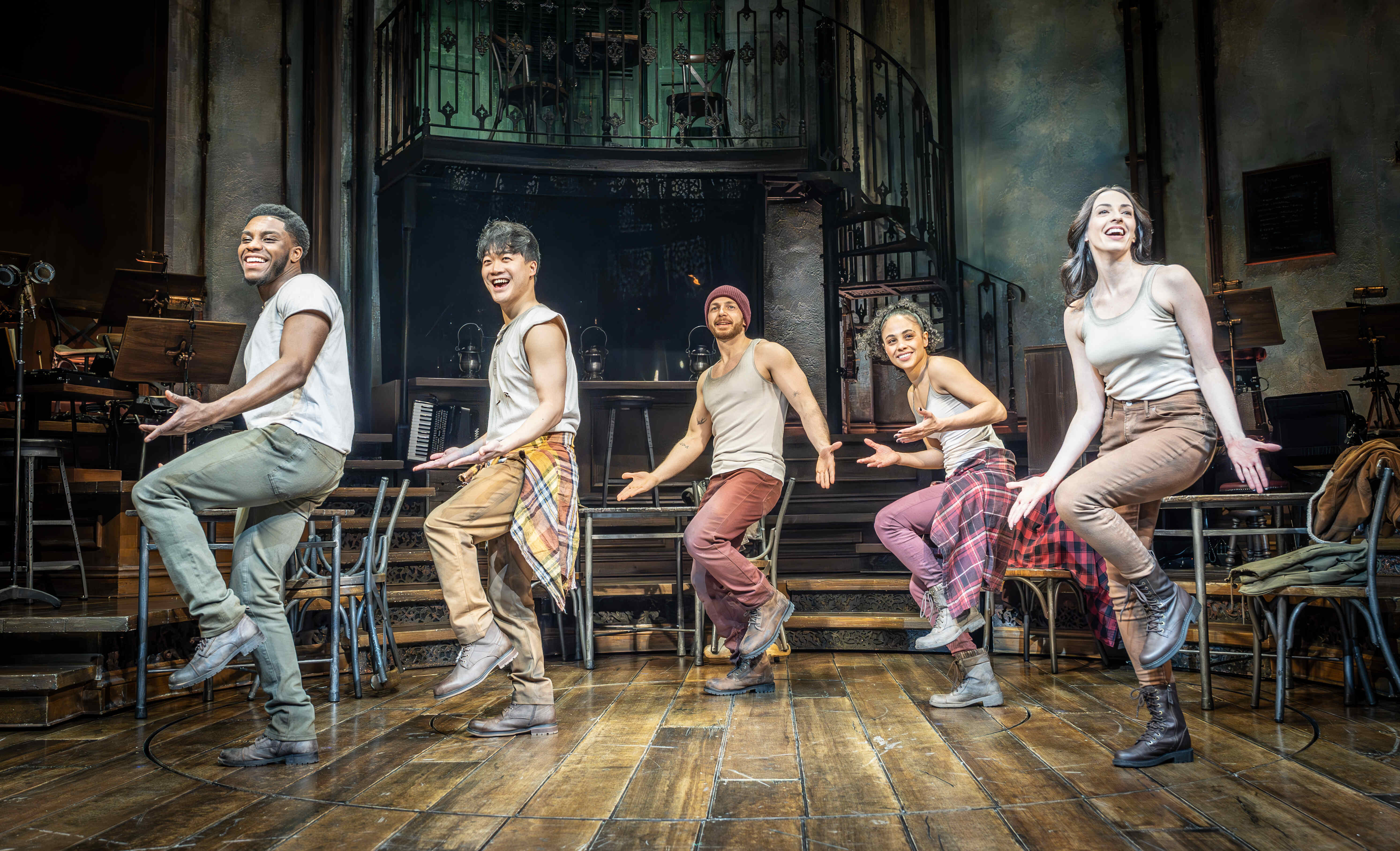Group choreography in Hadestown with glowing set design – photo by Marc Brenner