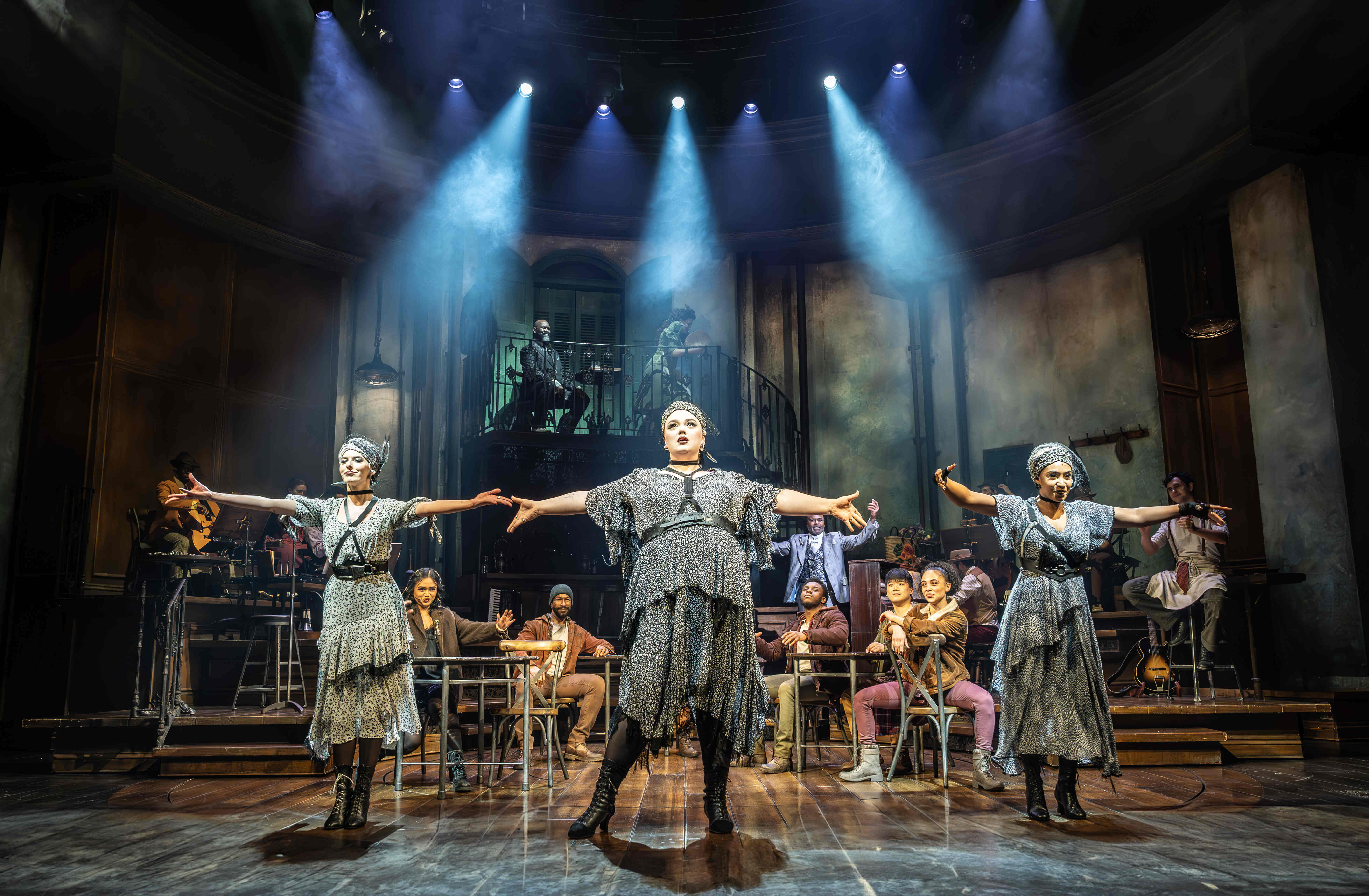 Hadestown cast lit in rich red and gold hues – photo by Marc Brenner