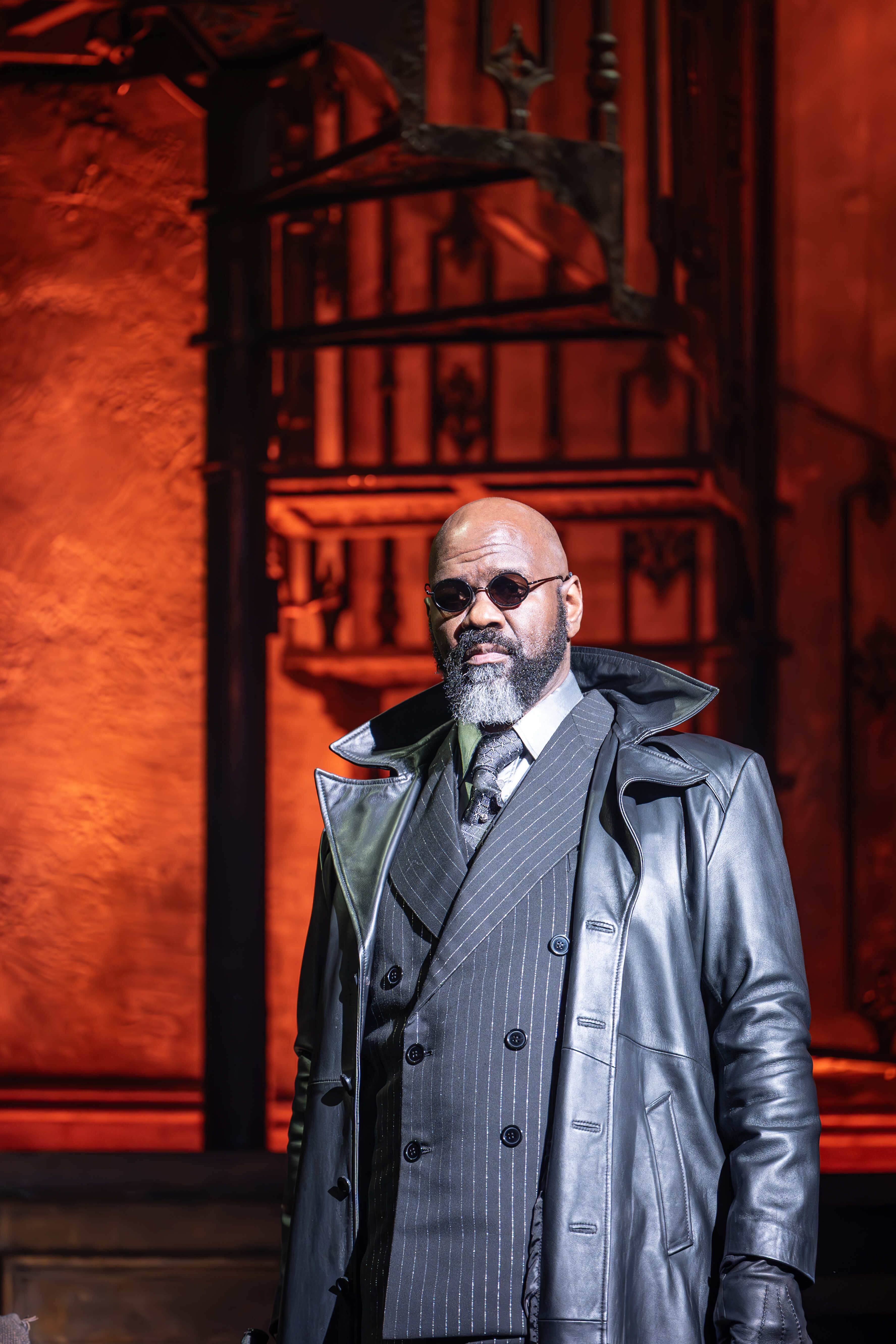 Hadestown cast performing under moody stage lights – photo by Marc Brenner