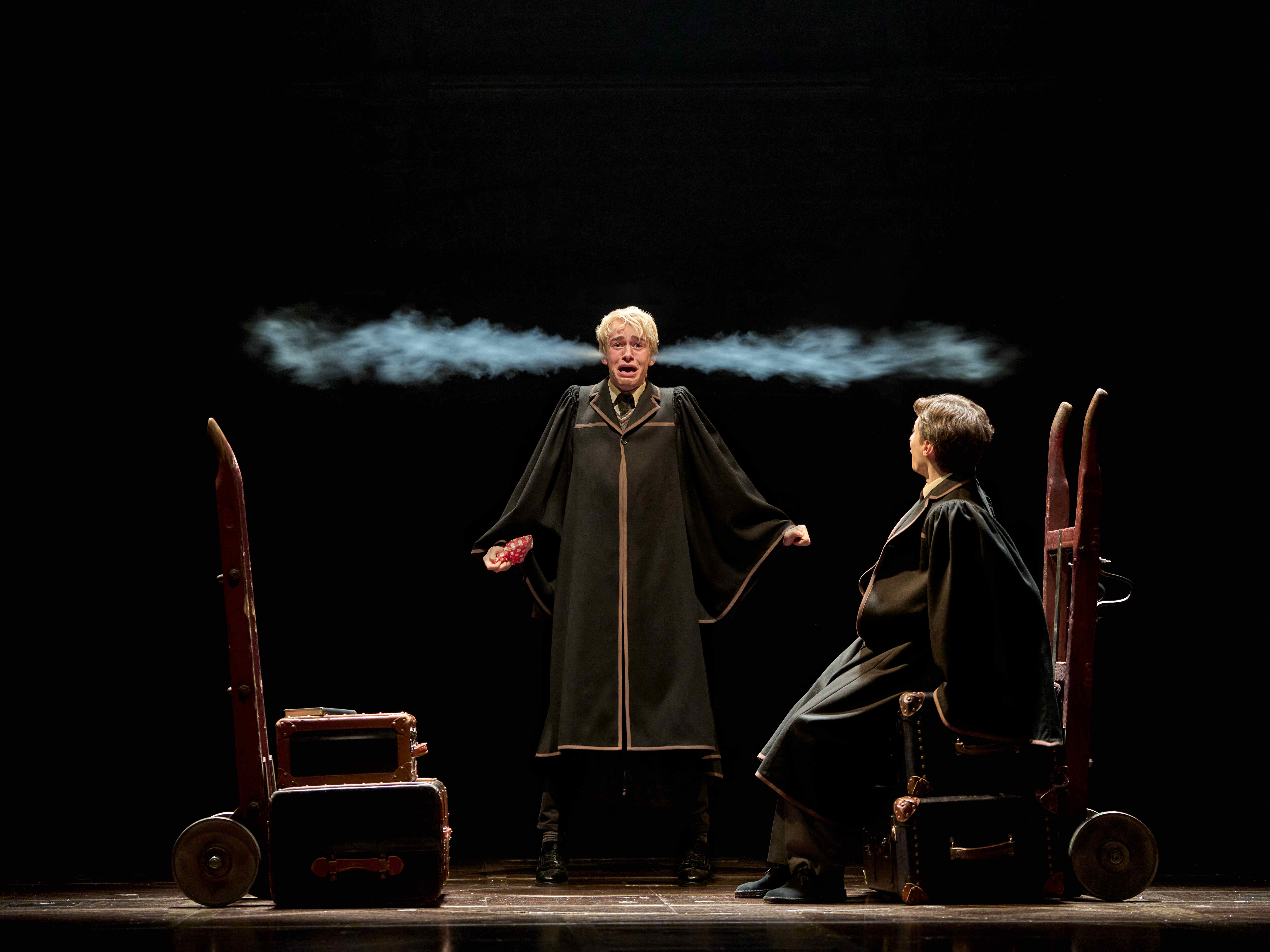 Actor in black robe with magical smoke effects on stage in Harry Potter and the Cursed Child.