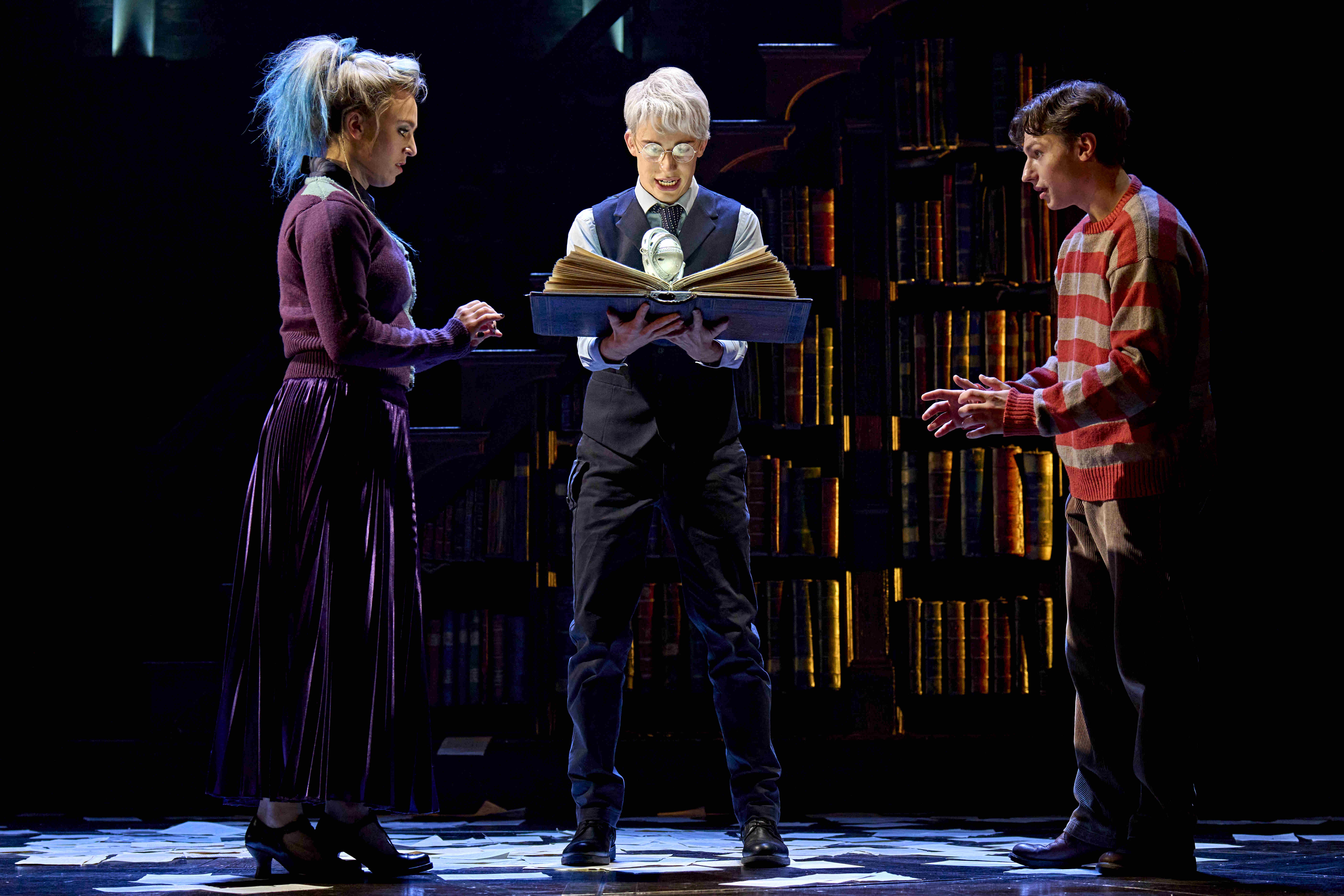 A group of Hogwarts students holding house banners in a powerful pose during a magical moment in Harry Potter and the Cursed Child.