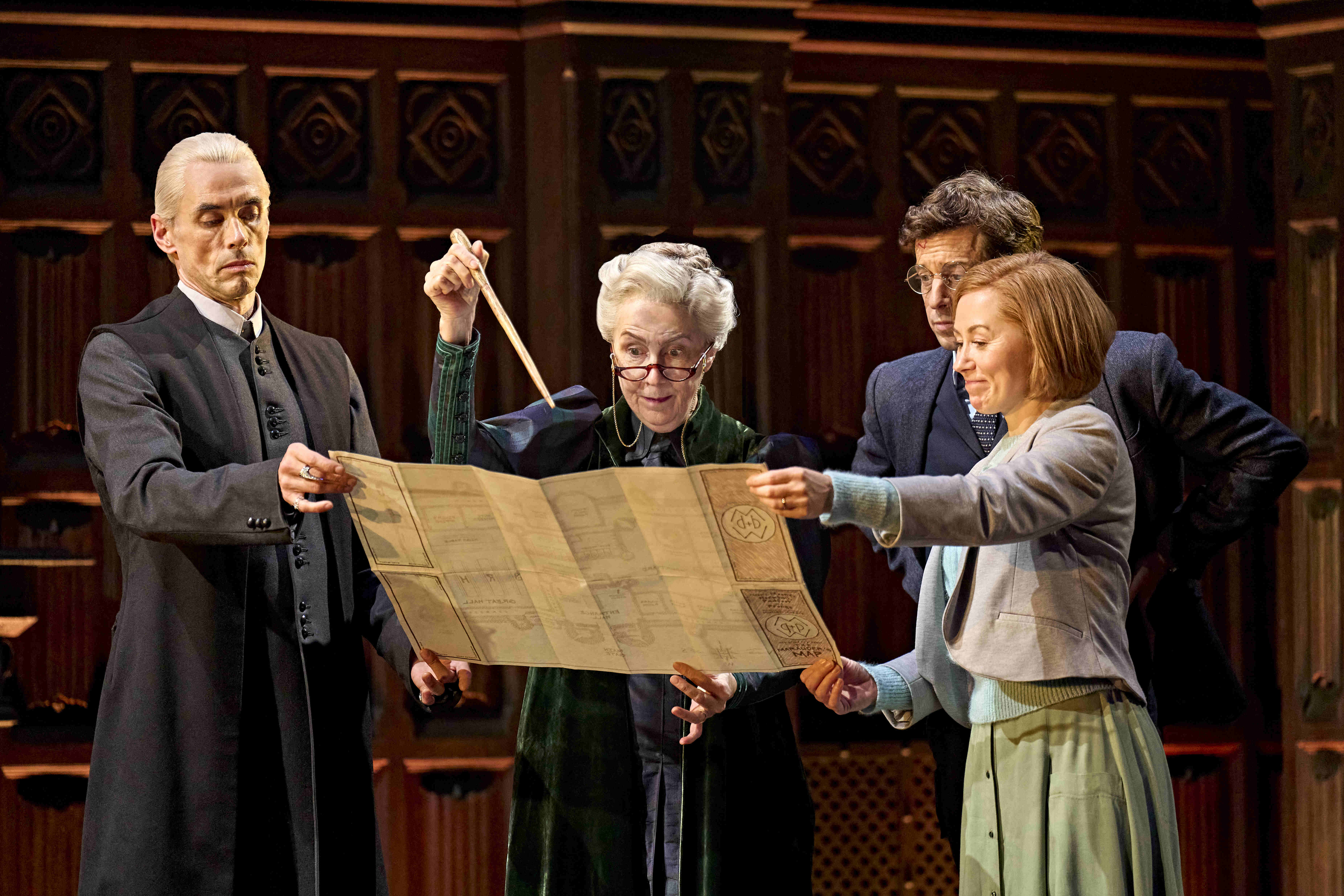 Actor playing Severus Snape in black robe, staring with a serious expression on stage in Harry Potter and the Cursed Child.