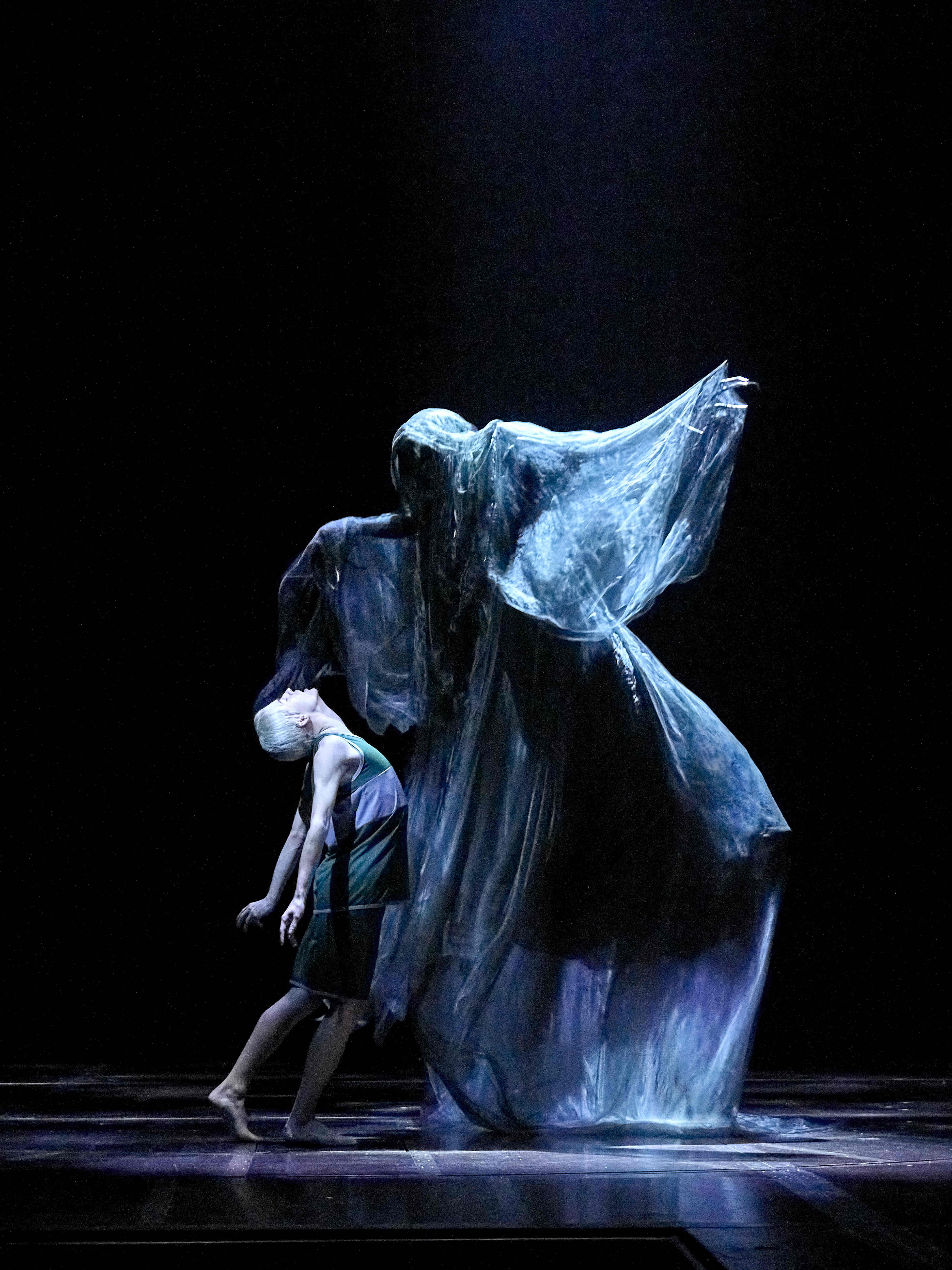 Ghostly figure looming over a character in a green dress, dramatic scene from Harry Potter and the Cursed Child.