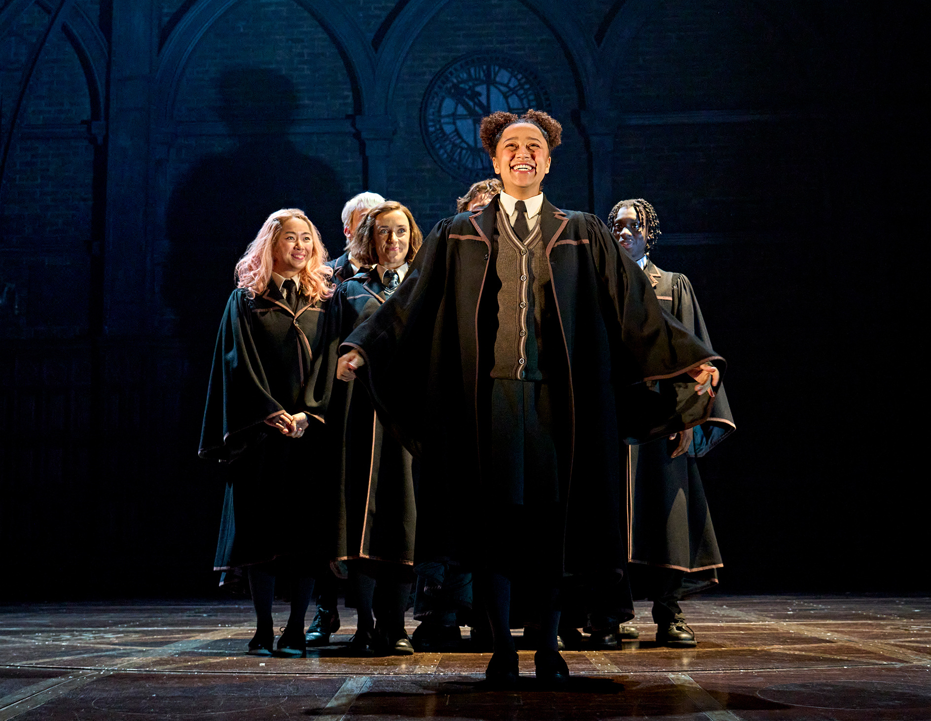 Sorting Hat ceremony with character being sorted into a house, Hogwarts house banners in the background, from Harry Potter and the Cursed Child.