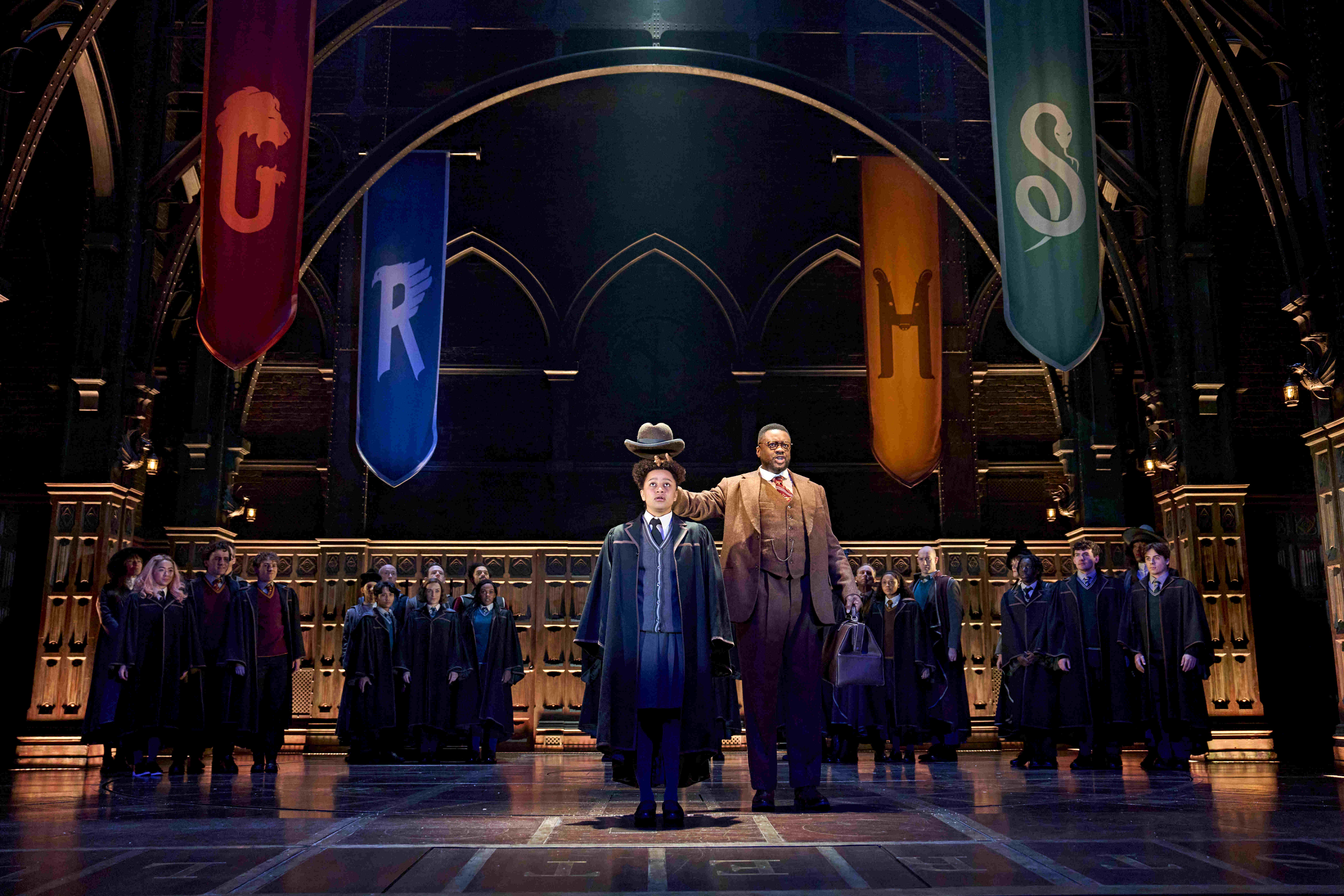 Group of Hogwarts students in robes laughing and enjoying themselves on stage in Harry Potter and the Cursed Child.