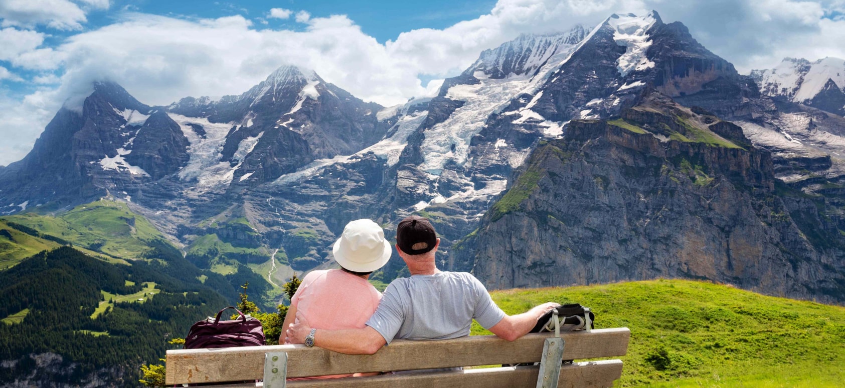 older couple sitting together enjoying beutiful view of mountian.