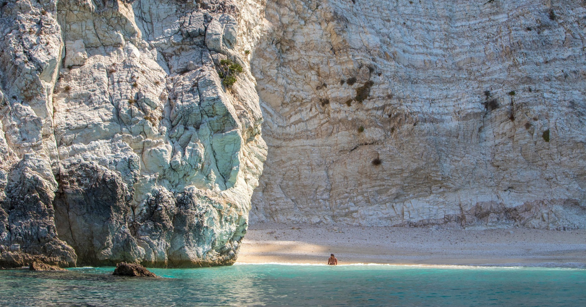 White limestone cliffs and turquoise waters along the coastline of Ithaca, Greece.