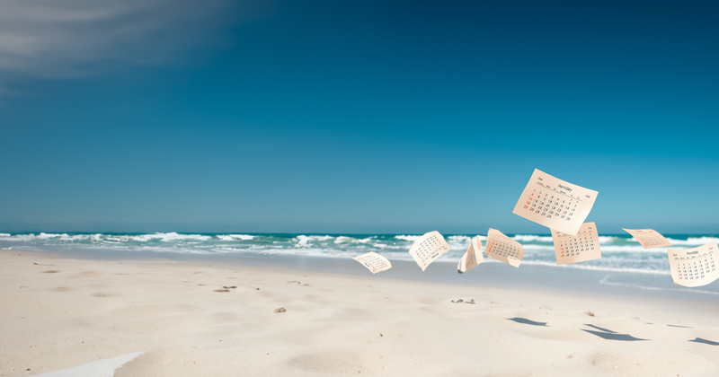 Loose calendar pages blowing across a sunny beach with soft sand, clear blue sky, and ocean waves – passing time and summer holiday vibe.