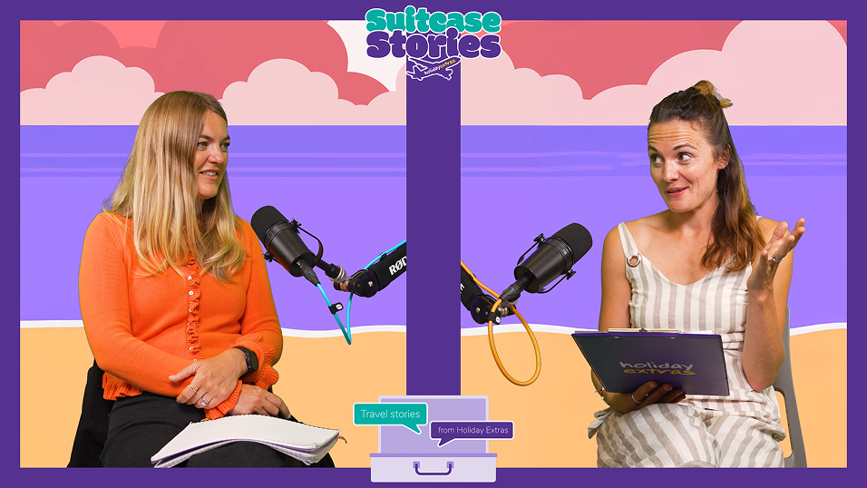 Two women recording a Suitcase Stories podcast episode with microphones and notes, seated in front of a colorful beach-themed backdrop — travel chat by Holiday Extras.