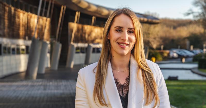 Alice Lawson, Associate Director of Insurance at Holiday Extras, standing confidently outside a corporate building — discussing political travel risks and insurance concerns.