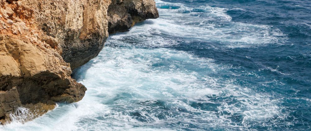 Waves crashing against the rocky coastline of Majorca, Spain.