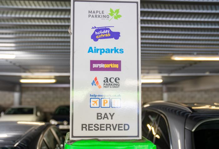 Car park at Holiday Extras Meet & Greet South Gatwick Airport showing a reserved bay with logos for Holiday Extras, Airparks, and Maple Parking