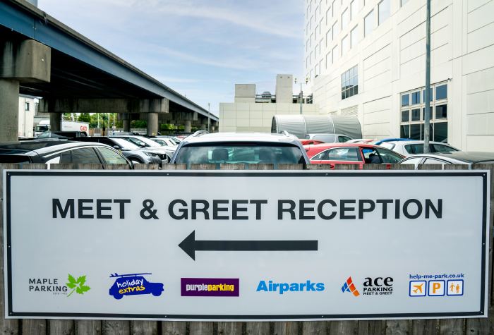 Meet & Greet reception sign at Gatwick North Terminal showing logos for Holiday Extras, Purple Parking, and Airparks