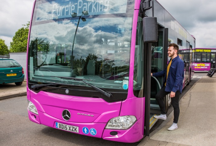 Man boarding a Purple Parking Park & Ride shuttle bus from the car park to Gatwick Airport
