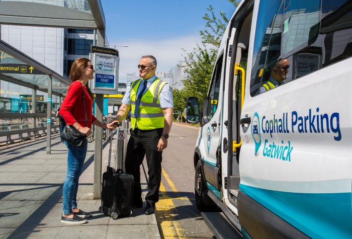 Male Cophall Parking Park & Ride shuttle bus driver speaking with a female passenger about to board at Gatwick Airport