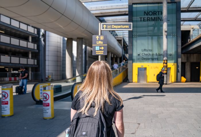 Female passenger walking toward the North Terminal at Gatwick Airport after dropping off her car with Meteor Parking Meet & Greet