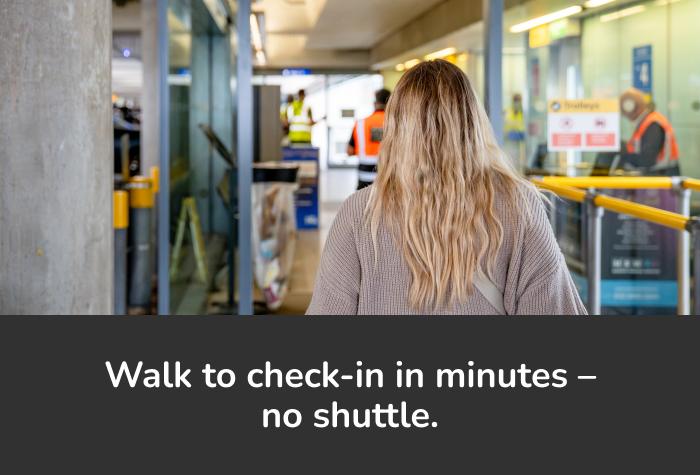 Woman giving car keys to friendly Maple Parking staff member at Heathrow Park and Ride reception with text reading 'You'll be met by the Maple team at the desk'