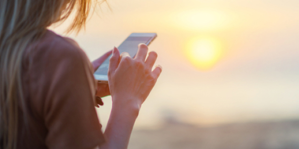 someone using their phone by the beach