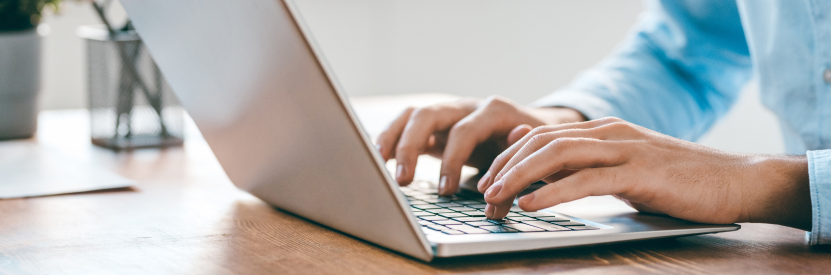 A close-up of hands typing on a laptop, completing an online form. Declaring medical conditions when booking travel insurance online ensures the right level of cover for a trip.