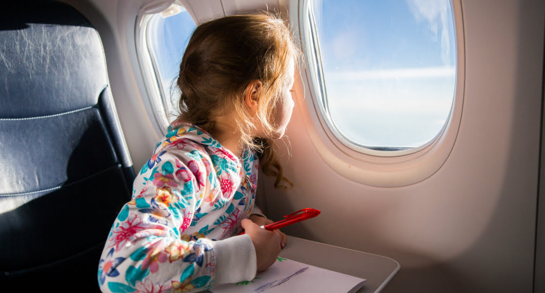 child on a plane looking out the window