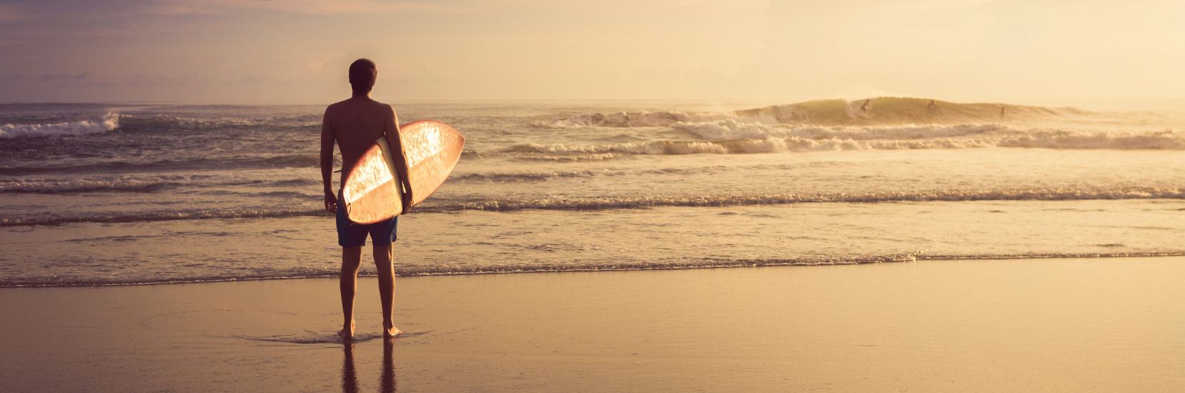 Happy older couple splashing in the sea on a sunny beach holiday, enjoying peace of mind with single travel insurance