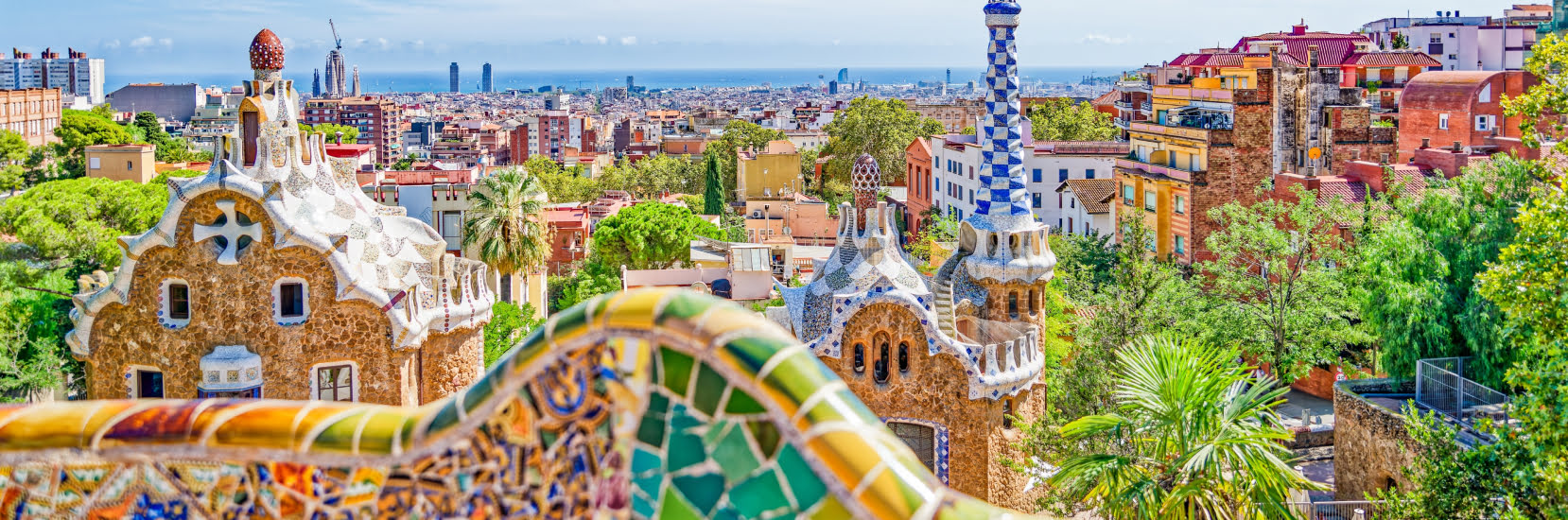 A colourful view of Park Güell in Barcelona overlooking the city and coastline.