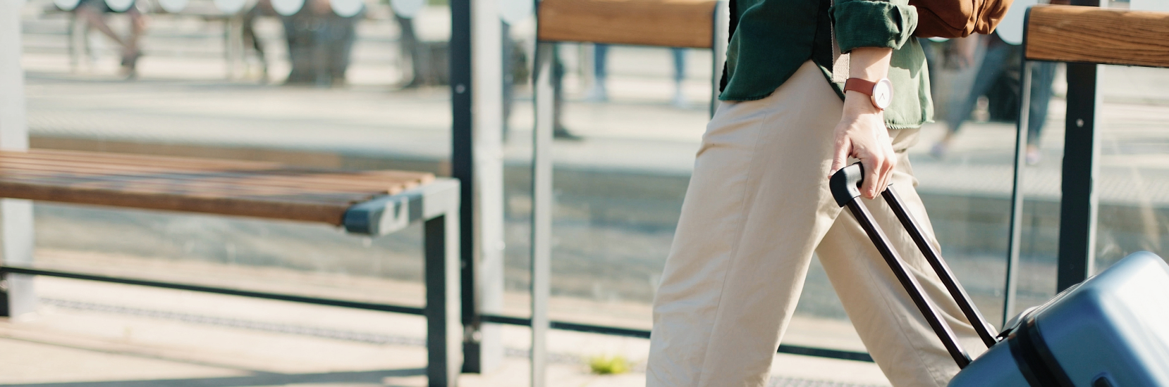 A person walking with a suitcase at a transport station, representing the experience of travelling with gallstones and the importance of planning ahead to manage symptoms while on the move.