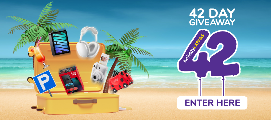 Giveaway prizes bursting out of an open suitcase on a beach