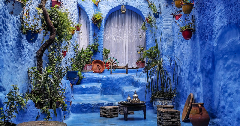 A traveller exploring a vibrant medina street lined with colourful lanterns and tiled archways