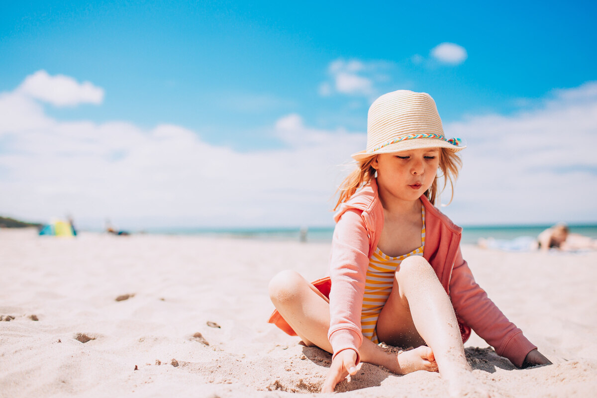 Kind spielt im Sand am Strand