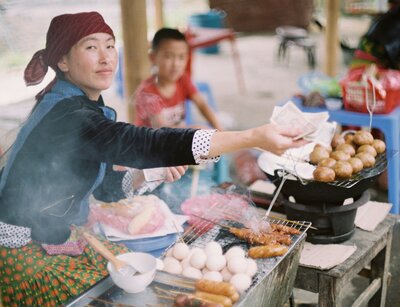 Frau serviert Essen an einem Stand auf der Straße in Vietnam