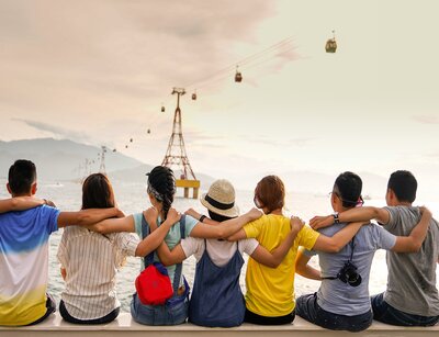 Gruppe junger Leute sitzen unter einer Seilbahn