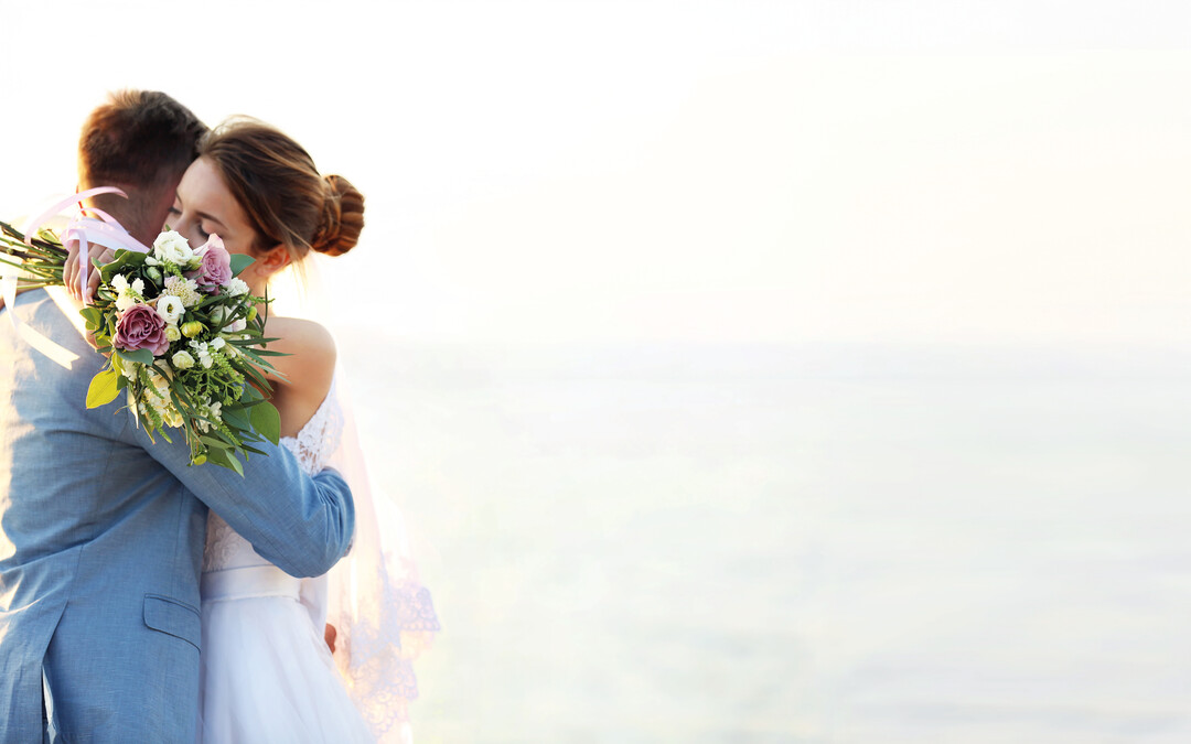 A married couple hugging by the sea