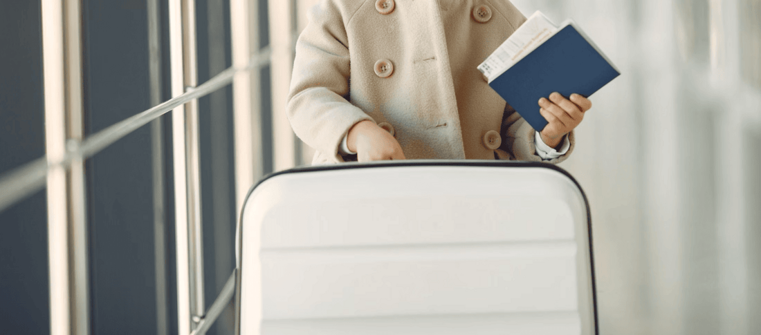 child with suitcase holding documents